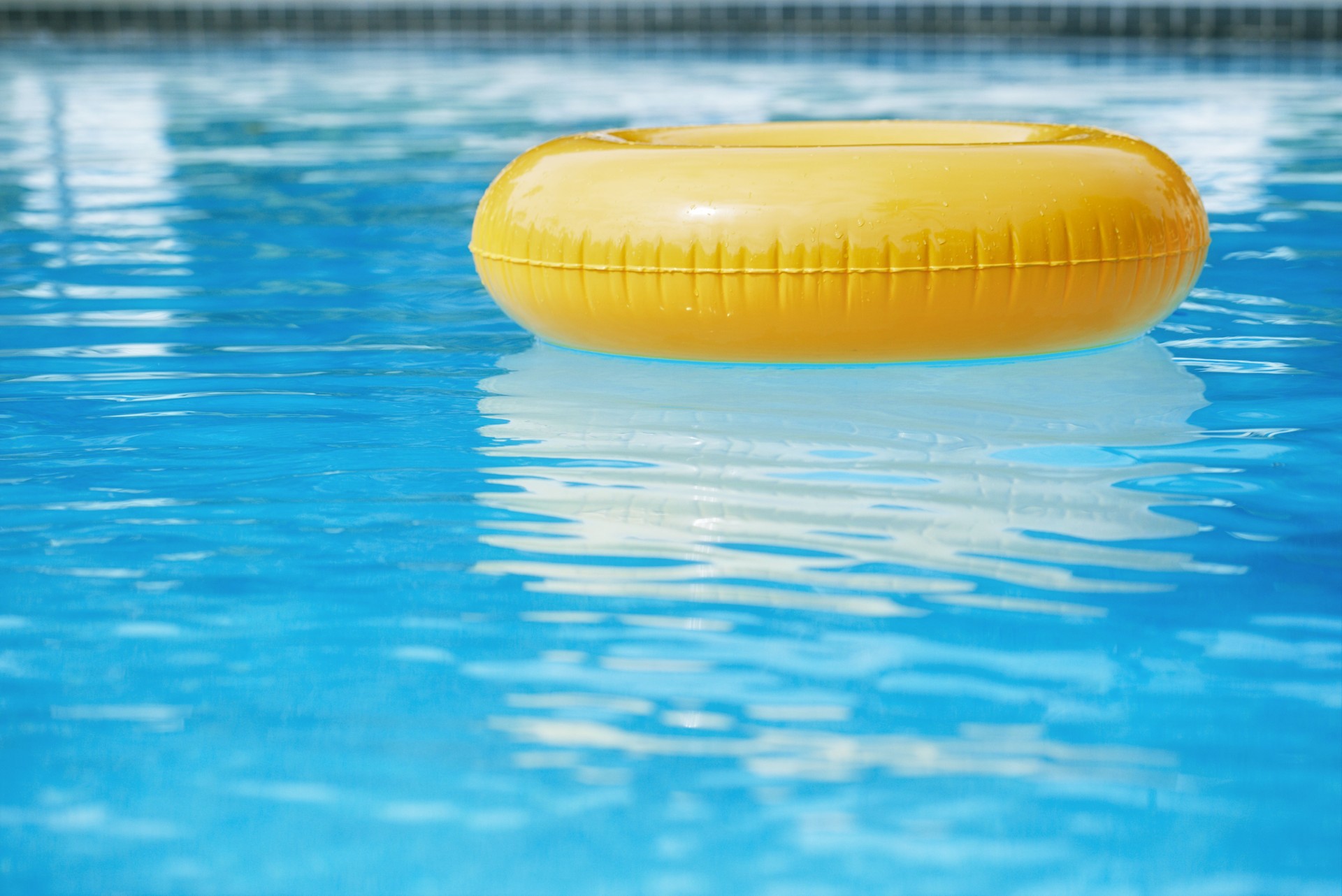 floating ring on blue water swimpool with waves reflecting